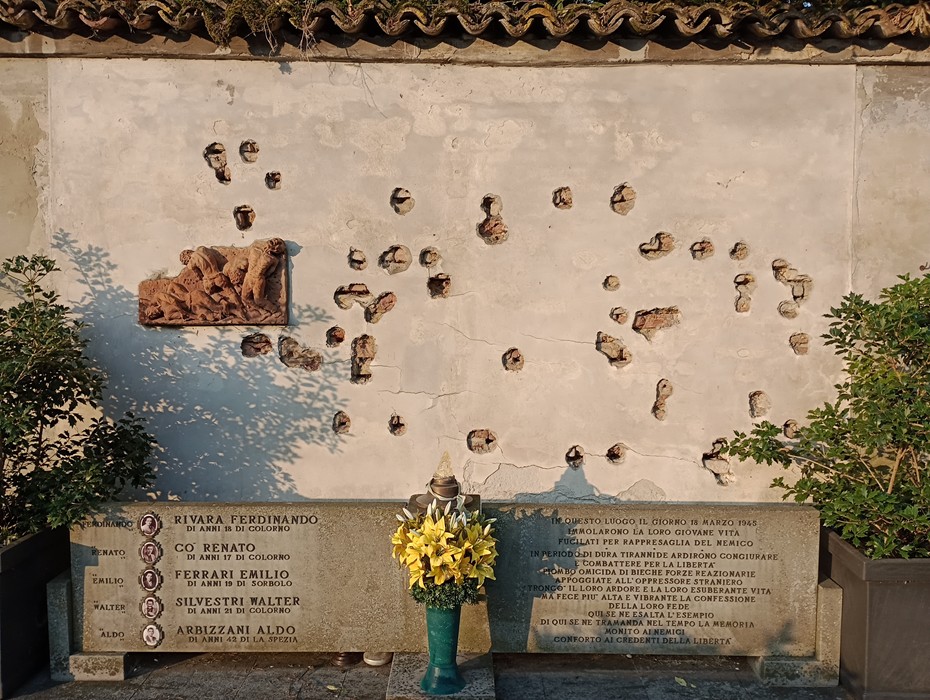 Monumento in memoria dei caduti del 18 marzo 1945, con simboli di commemorazione e omaggio floreale.