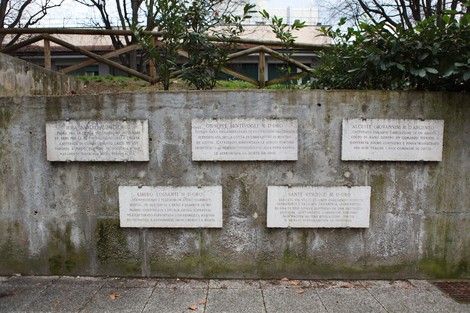 Lapidi commemorative dedicate ai giovani caduti nella lotta partigiana. Ambiente urbano e silenzioso.