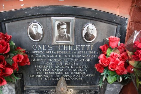 Sepolcro di Chiletti con fotografie e fiori, dedicato a Ones Chiletti, simbolo di memoria e onore.