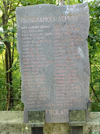 Memoriale in pietra commemorativo dedicato ai caduti della Benedicta, immerso nella natura.