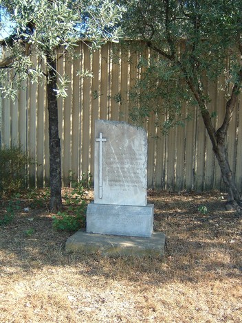 Cippo della Fabbrica Bacci tra ulivi, un monumento che ricorda la storia locale.