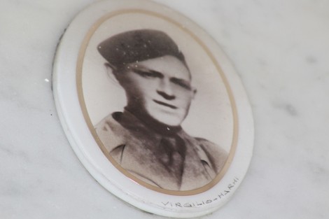 Fotografia di una targa commemorativa con un ritratto di un soldato, parte del Sacrario dei caduti per la Liberazione.