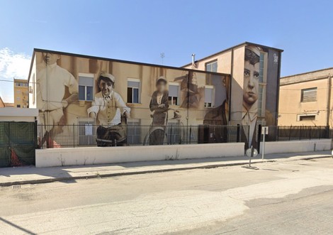 Murale dedicato a Butera, raffigurante figure storiche su un edificio in un contesto urbano.