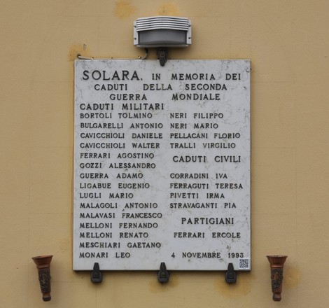 Lapide commemorativa ai caduti di Solara, con nomi di militari e civili, situata su un muro.
