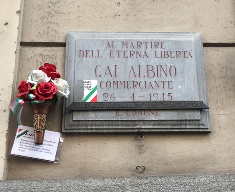 Lapide commemorativa dedicata a Gai Albino, martire della libertà, situata in un contesto storico.