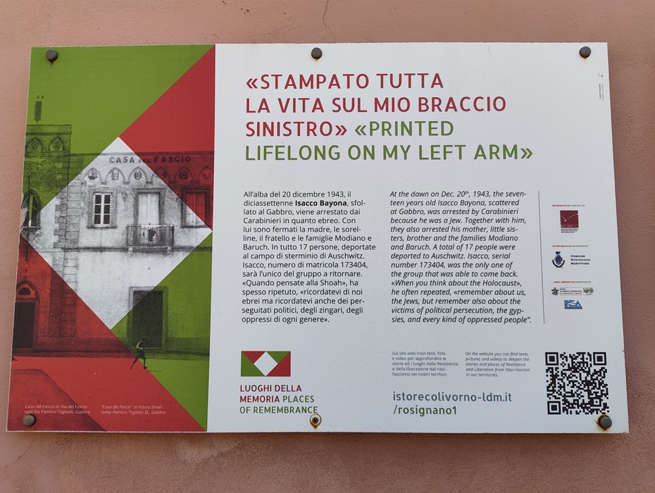Targa metallica con testo bilingue italiano-inglese e riquadro decorativo tricolore su sfondo bianco.