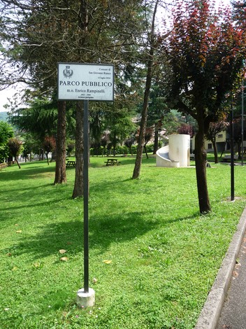 Monumento a Rampinelli situato in un parco pubblico, circondato da vegetazione e spazi verdi.