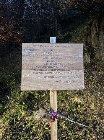 Monumento alla battaglia di Bosco Martese con cartello informativo su eventi storici della Resistenza.