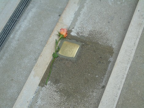Pietra d'inciampo ad Almansi con una rosa posata accanto, simbolo di memoria e rispetto.
