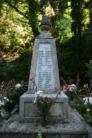 Monumento dedicato alle vittime dell'eccidio di Guardistallo e Montescudaio, con fiori commemorativi.