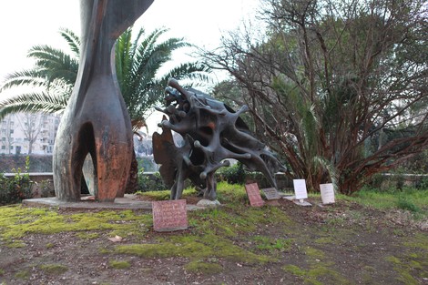 Monumento a Matteotti con scultura astratta e vegetazione circostante, simbolo di memoria e riflessione.
