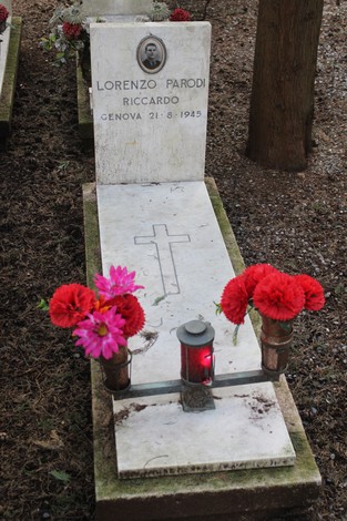 Tomba con fiori rossi, commemorando Lorenzo Parodi, caduto per la libertà. Atmosfera di rispetto e memoria.