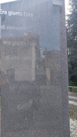 Monumento alla Resistenza con iscrizioni commemorative su una superficie di pietra.
