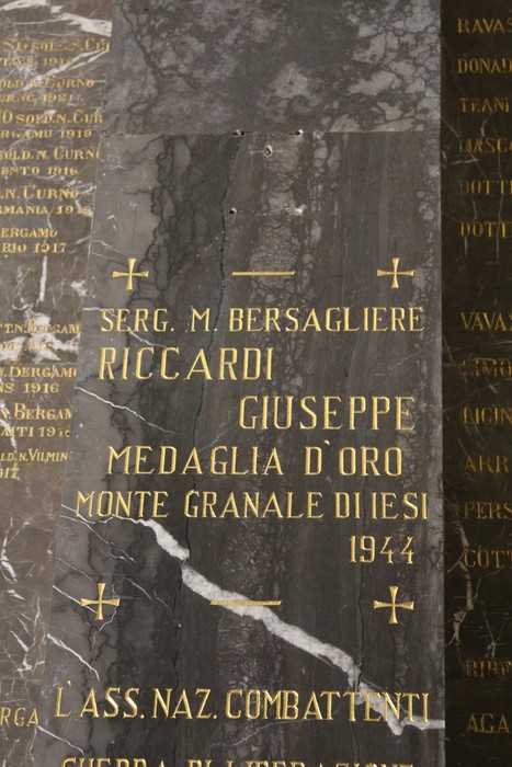 Dettagli del Tempio dei Caduti con iscrizioni commemorative su un pannello di pietra.