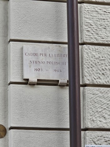 Lapide commemorativa dedicata a Stenio Polischi, situata su un muro in un contesto urbano.