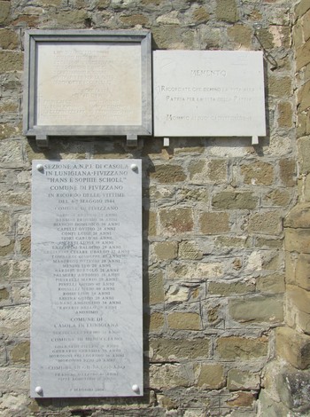 Lapide commemorativa in pietra dedicata alla strage di Mommio, con iscrizioni e nomi delle vittime.