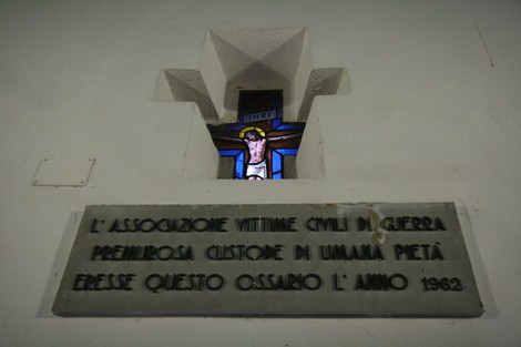 Cappella dei Martiri con vetrate artistiche e lapide commemorativa in un ambiente di riflessione.