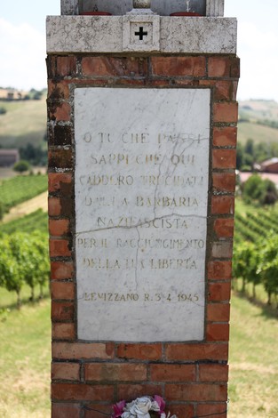 Cippo commemorativo dedicato a Baldini e Raimondi, situato tra le vigne, con dedica storica.