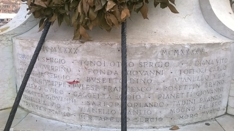 Monumento ai caduti dei Carmini con nomi incisi in memoria dei defunti e allestito con fiori.