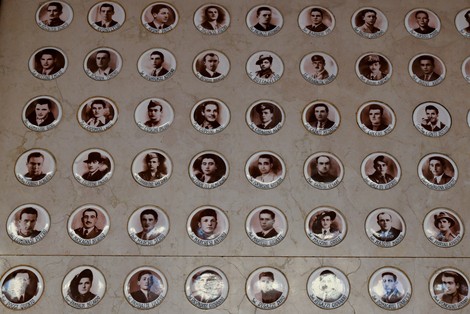 Sacrario dei caduti per la Libertà con ritratti in ceramica su fondo chiaro. Memoria e rispetto per i defunti.