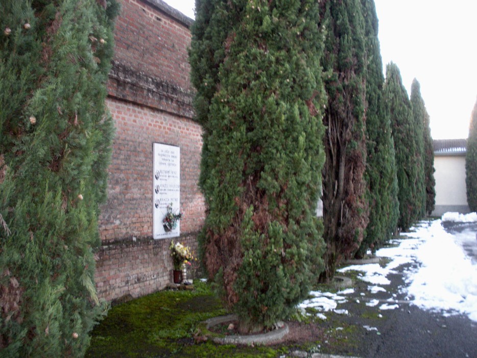 Lapide commemorativa a Vercesi, Beltrami e Miracca, incorniciata da cipressi e circondata da neve.