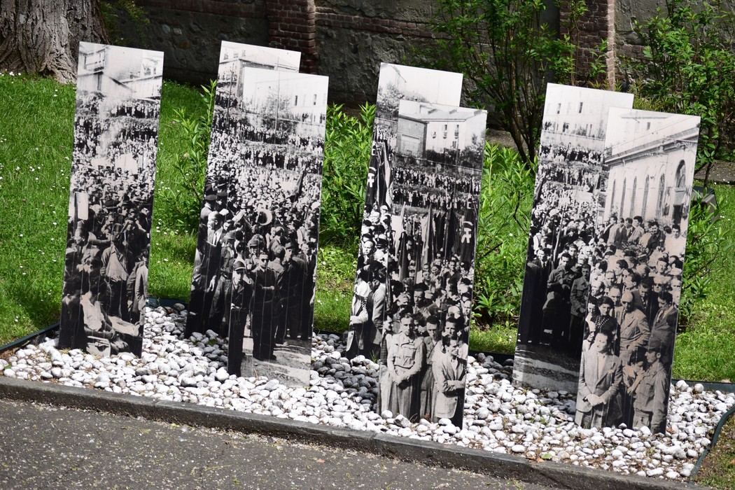 Mostra al pubblico storiche fotografie in bianco e nero, che commemorano eventi significativi, disposte in un romantico giardino.