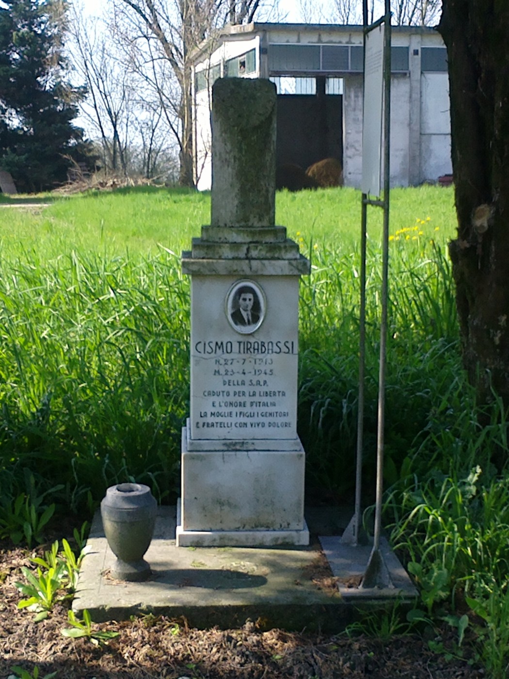 Cippo commemorativo di Cismo Tirabassi, situato in un'area verde e tranquilla.