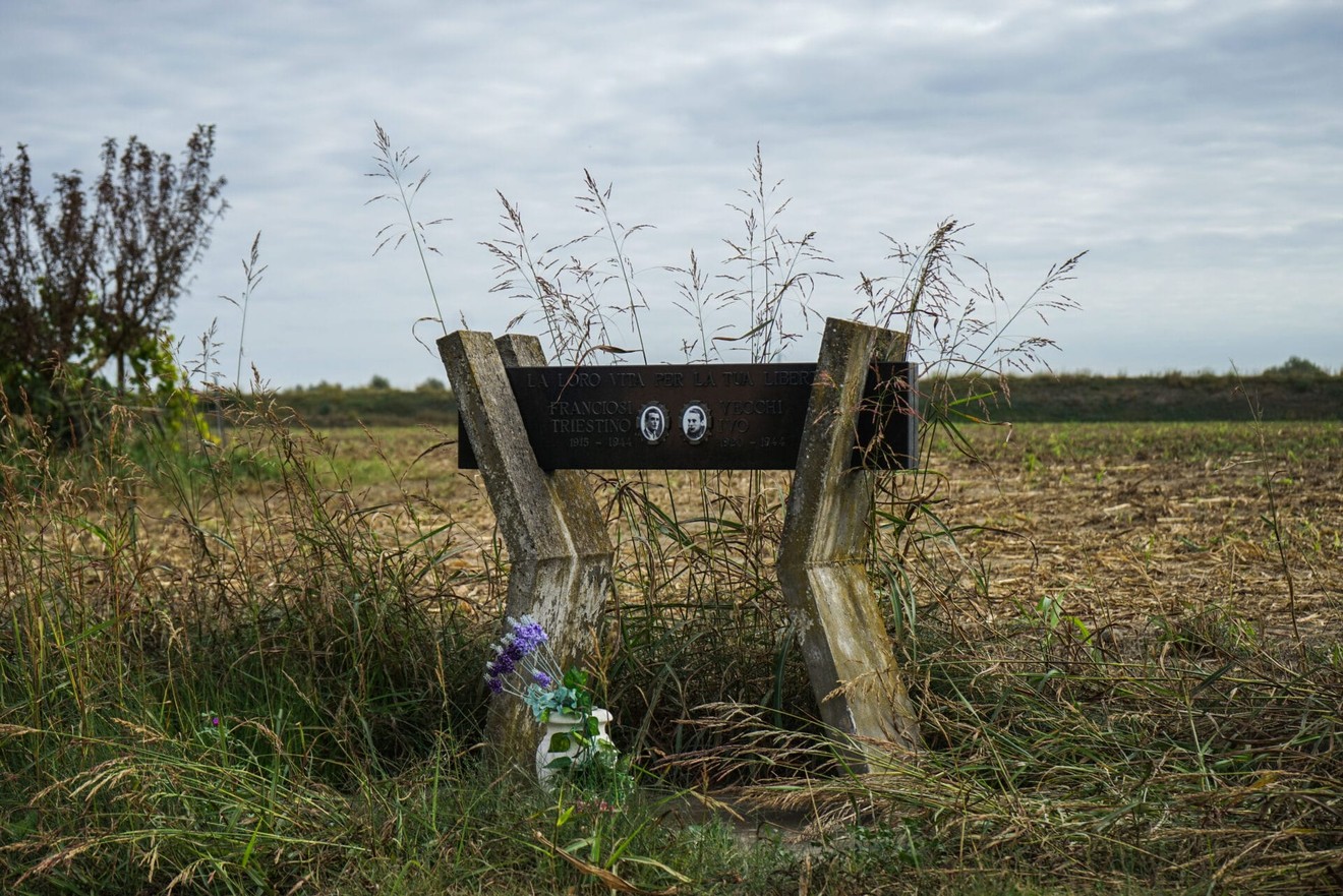 Monumento commemorativo a Franciosi e Vecchi, circondato da vegetazione in un'area rurale.