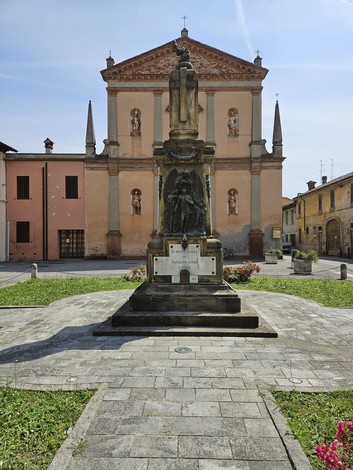 Monumento ai Caduti di Castiglione d'Adda, situato in una piazza con edifici storici sullo sfondo.