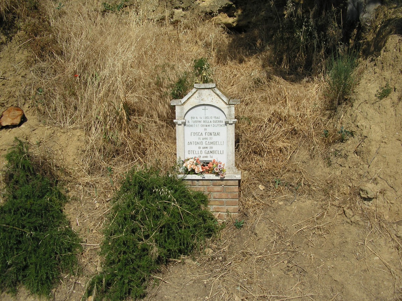 Cippo commemorativo dedicato a Fontani e ai fratelli Gambelli, situato in un contesto naturale.