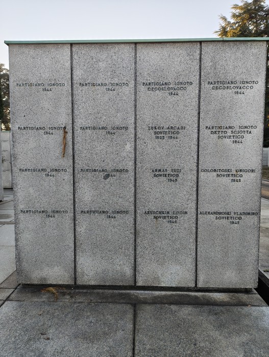 Monumento commemorativo con lastre in pietra che riportano nomi e date, dedicato ai caduti della guerra.