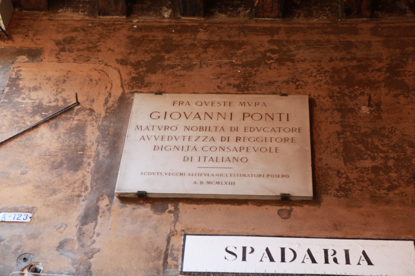 Lapide commemorativa dedicata a Giovanni Ponti, visibile in un ambiente storico. Mostra onore e riconoscimento.