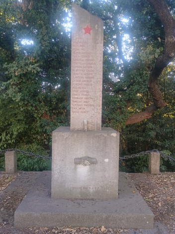 Monumento ai caduti per rappresaglia, caratterizzato da una stele con simboli e testi commemorativi.