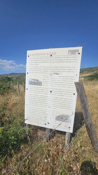 Rovine di Ca' di Guzzo immerse nella natura, con pannello informativo sullo scontro storico.