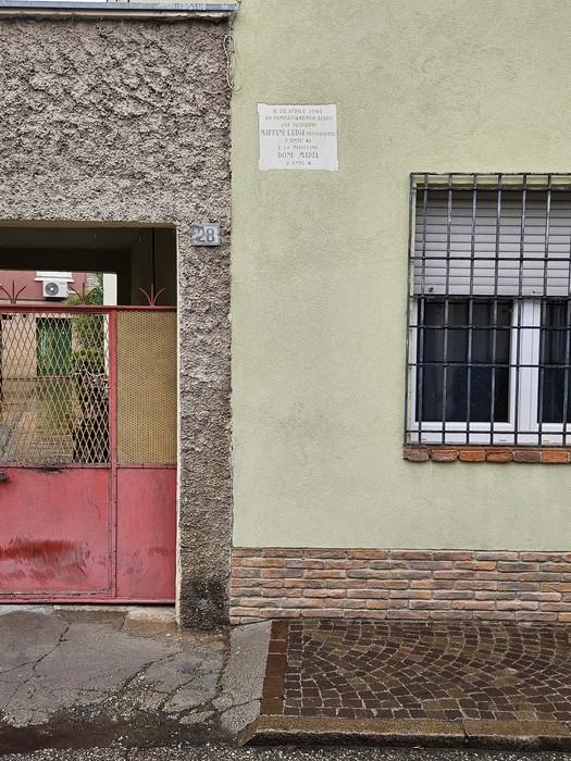 Lapide commemorativa alle vittime del bombardamento del 22 aprile 1945, su un muro di un edificio.