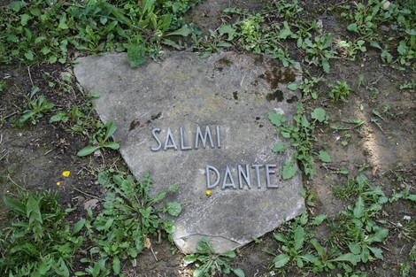 Monumento commemorativo nel cimitero di Stia, incastonato in un contesto naturale.
