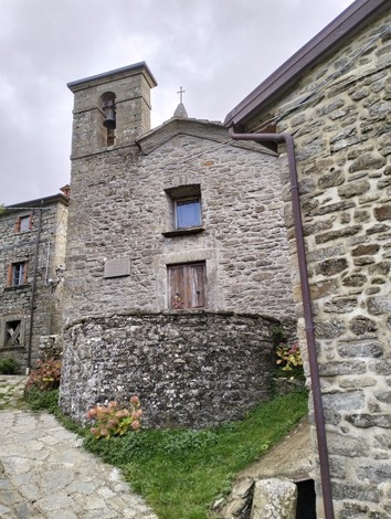 Lapide commemorativa a Nencetti, situata in un caratteristico borgo in pietra.