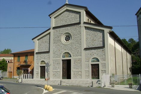Tempio dei caduti: edificio commemorativo con architettura in pietra, situato in un contesto urbano tranquillo.