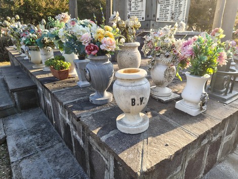 Sacrario ai caduti con vasi di fiori e decorazioni commemorative in un contesto solenne e rispettoso.