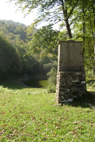 Monumento dedicato alle donne della Val Verde, immerso nella natura vicino a un lago.