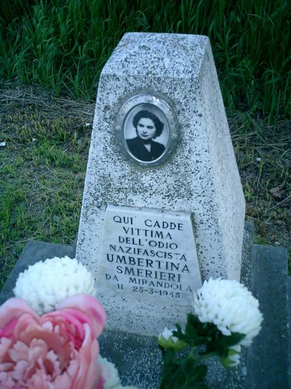Cippo commemorativo dedicato a Umbertina Smerieri, vittima del nazifascismo a Mirandola, con fiori.