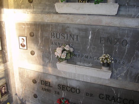 Cappella dei partigiani con urne funerarie e decorazioni floreali in memoria dei caduti.