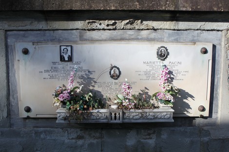 Memoriale dedicato alle vittime dei bombardamenti, decorato con fotografie e fiori.