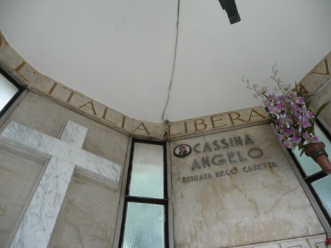 Sacrario ai caduti partigiani, interno con decorazioni e un omaggio floreale.
