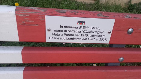 Panchine colorate nel parco Donne della Resistenza, commemorazione di Elda Chiari. Atmosfera di riflessione e memoria.
