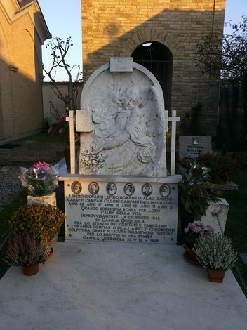 Monumento commemorativo ai caduti per residuato bellico a Casola Querciola, con decorazioni e omaggi floreali.