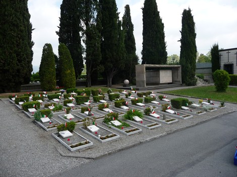 Campo dei caduti per la Libertà, un luogo di rispetto con cipressi e tombe decorate, simbolo di memoria e sacrificio.