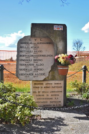 Monumento ai caduti per la libertà di Paganine, con iscrizioni commemorative e fiori in omaggio.
