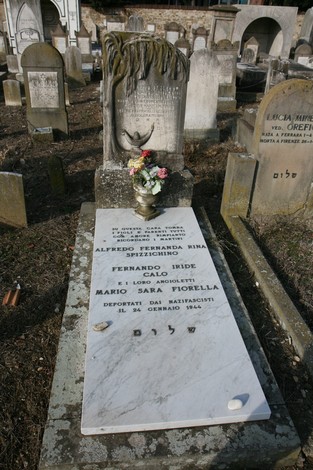 Cenotafi commemorativi con nomi dei deportati nel cimitero ebraico, tra resti di tombe antiche.