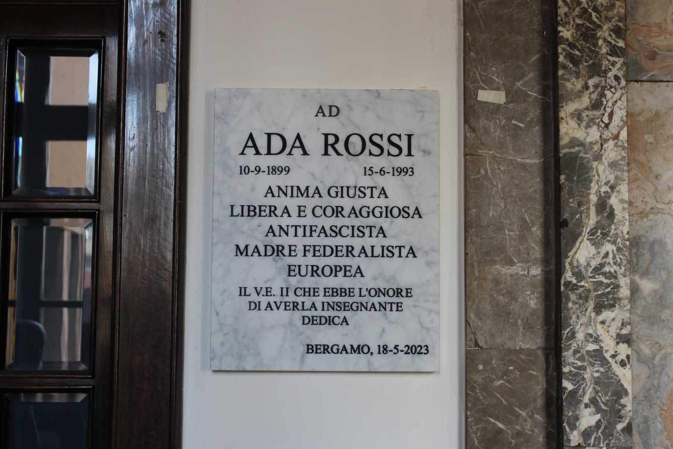 Lapide commemorativa in marmo dedicata a Ada Rossi, con iscrizioni sul suo impegno e valore.